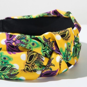 Detail of fabric knotted headband with yellow polka dot and feather pattern for carnivals