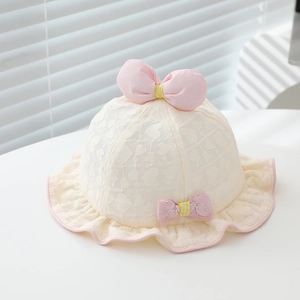Détail d'un chapeau de soleil bébé avec dentelle en cœur et accents de nœuds roses
