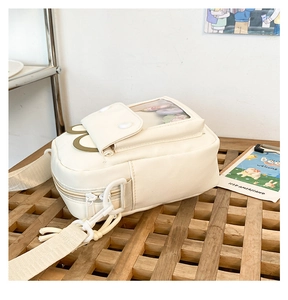 Detail of white mini crossbody ita bag with clear window on a wooden table setup