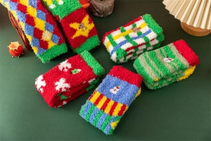 Close-up of festive Christmas coral fleece socks with colorful patterns like deer and snowman