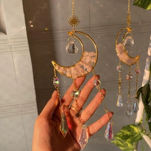 Detailed shot of golden moon suncatcher with pink natural crystals and faceted prisms