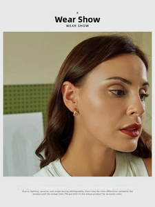 Orecchini a cerchio dorati a forma di U indossati su modella per un look minimalista