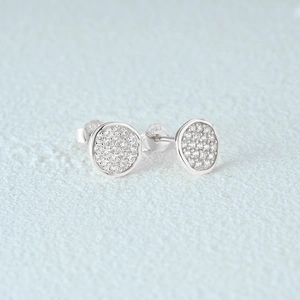 Macro shot of silver S925 earrings with pavé set white zircon stones on circular studs