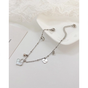 Detailed shot of silver steel bracelet with heart shell pendant and Love engraving