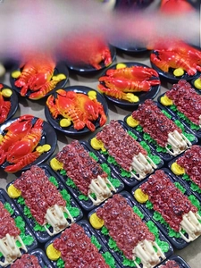 Detailed macro view of miniature 3D lobster and meat skewers resin food magnets