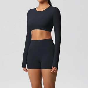Detail of high-stretch matte black fitness set featuring long sleeve crop top and shorts