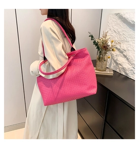 Detail showing high-capacity woven shoulder bag in rose pink with a soft textured finish