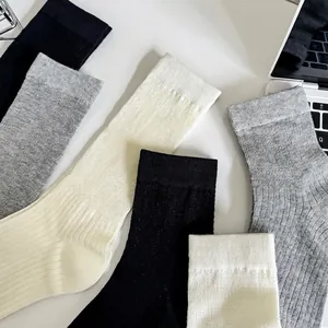 Set of three ribbed cotton socks in black, grey, and white with vertical knit texture
