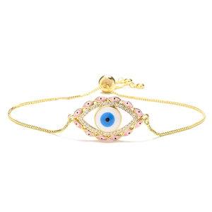 Detailed macro view of the gold Evil Eye charm with blue enamel and cubic zirconia stones