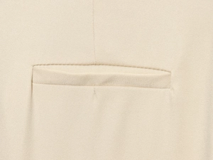 Vue macro détaillée de la texture du tissu sergé beige et des coutures de la poche