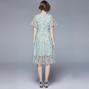 Rückansicht eines hellgrünen floralen Spitzenkleids mit Lotusärmeln und hoher Taille