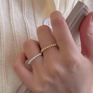 Minimalist 925 sterling silver beaded ring in gold and silver finish worn by a model