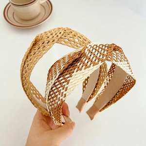 Détail de serre-têtes en raphia tressé en beige et marron avec texture artisanale