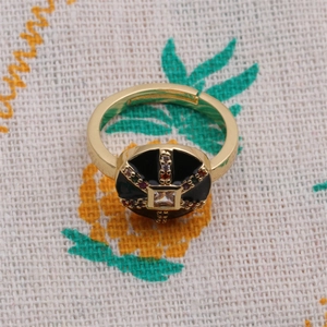 Vue détaillée d'une bague dorée avec émail noir et zircons multicolores sertis