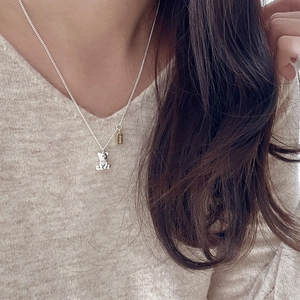 Minimalist 925 silver necklace with silver bear pendant and gold LOVE charm on a model