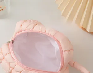 Close-up of pink quilted makeup bag showing soft pleated texture and zipper detail
