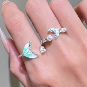 Detailed view of an open mermaid tail ring with gradient enamel and small pearls