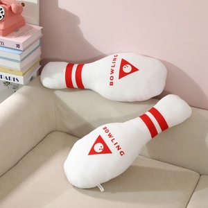 Creative bowling pin plush pillow set with red stripes and BOWLING print on sofa