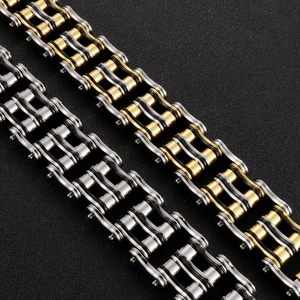 Detail of masculine bike chain bracelet in gold, silver and black stainless steel