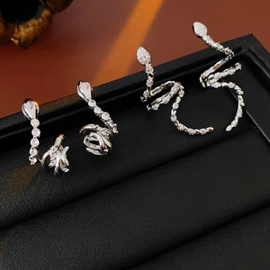 Detailed view of silver snake-shaped ear cuffs with sparkling zircon stone inlay