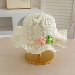 Close-up of children straw hat featuring crochet flowers and delicate lace ribbons