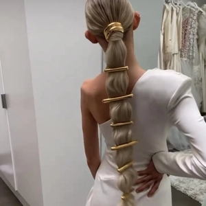 Detail of 7pcs golden metal elastic hair accessories set on a stylish ponytail