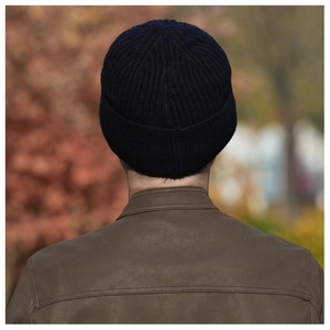 Close-up of dark blue ribbed knit beanie worn outdoors showing thick texture and warm material