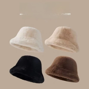 Detail view of plush faux fur bucket hats in four colors including white and coffee