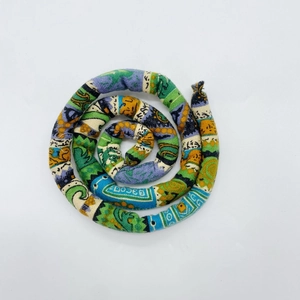Macro detail of colorful ethnic pattern fabric spiral dreadlock hair tie for high ponytail