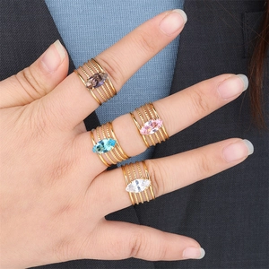 Detail of four gold-plated stainless steel rings with colorful marquise-cut zircons