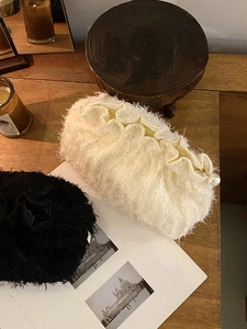 Détail de trousses à maquillage en dentelle pelucheuse avec fermeture à perle