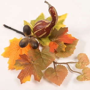 Close-up of artificial autumn maple leaves with realistic acorns and mini pumpkin