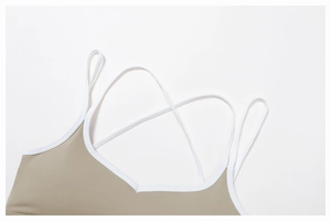 Dettaglio del reggiseno sportivo yoga kaki con bordi bianchi a contrasto e spalline incrociate
