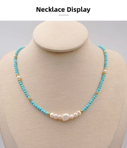 Detail of turquoise beads and baroque pearl necklace on a beige display bust stand