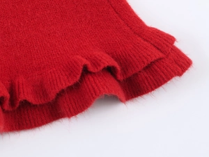 Close-up of bright red knitted fabric with soft texture and wavy ruffled hem detail