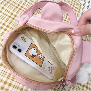 Top view of pink cartoon ear bag showing interior capacity with zipper closure and a smartphone