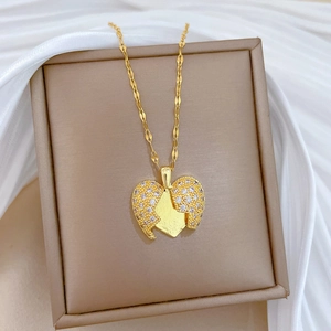 Detail of a gold broken heart pendant with crystals on a jewelry box and silk