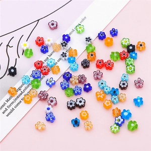 Colorful flower-shaped glass beads for DIY jewelry making laid on a decorative card