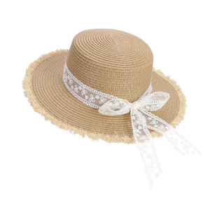Chapeau de soleil en paille avec large bord, ruban en dentelle blanche et nœud pour la plage