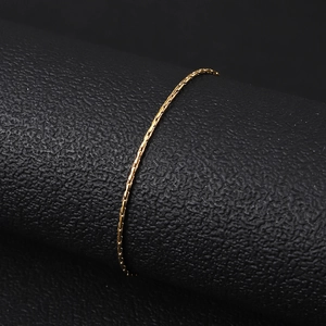 Detailed close-up of a delicate 18K gold-plated titanium steel bracelet on a black leather stand