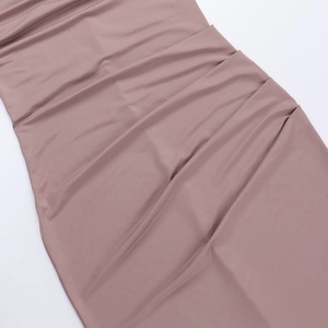 Detailed close-up of the elegant ruched texture and soft fabric of this dusty pink dress