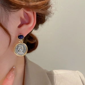 Detailed view of French vintage coin earrings with blue resin stud and embossed profile