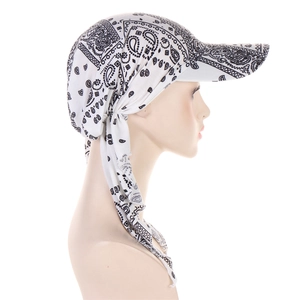 Detail view of white paisley turban hat with brim and back tie closure on model