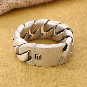 Macro detail of antique silver Cuban link bracelet featuring a rugged matte metal finish