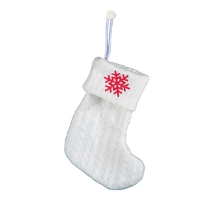 Close-up of white cable knit Christmas stocking with red snowflake embroidery