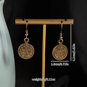 Macro shot of vintage bronze coin earrings with precise size and weight measurements