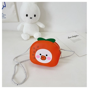 Detail of a mini orange crossbody bag featuring a cute duck face and green leaf accent