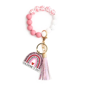 Macro shot of pink heart beaded wristlet keychain with rainbow tag and leather tassel