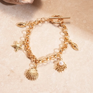 Détail d'un bracelet océan doré avec étoile de mer, coquillage, perle et fermoir OT