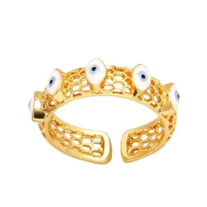 Bague ouverte dorée avec cinq yeux bleus en émail et un design ajouré en nid d'abeille